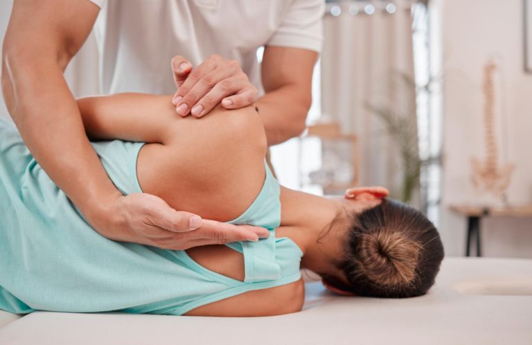 Quiropraxista realizando um ajuste manual na coluna vertebral de uma paciente em consultório.